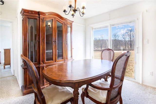 dining area with a chandelier and light colored carpet