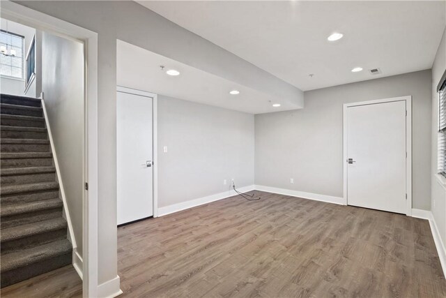 below grade area featuring stairs, recessed lighting, wood finished floors, and baseboards