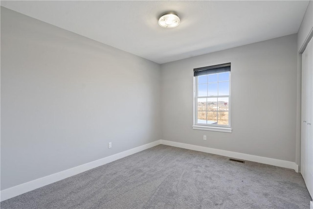 unfurnished room featuring carpet, baseboards, and visible vents