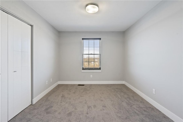 unfurnished bedroom with a closet, visible vents, baseboards, and carpet