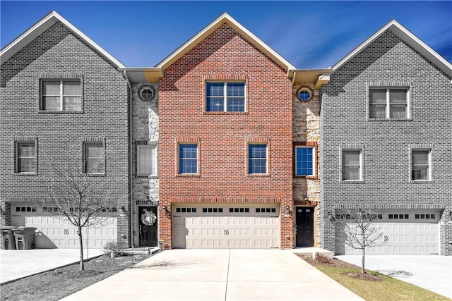 townhome / multi-family property featuring brick siding, concrete driveway, and a garage