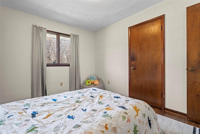 bedroom featuring baseboards and wood finished floors