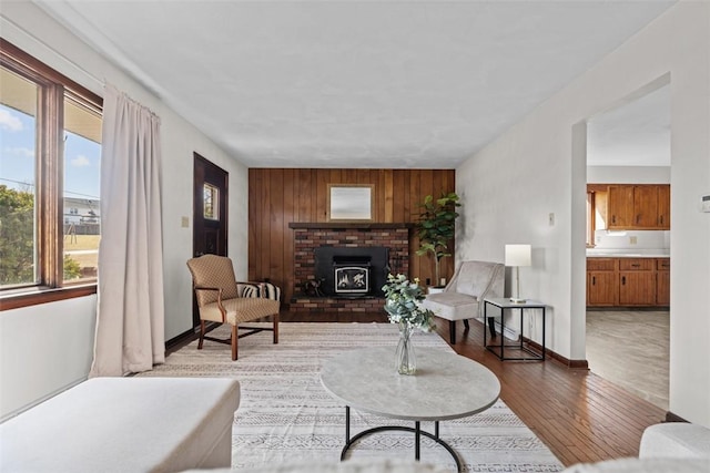 living room featuring wooden walls, baseboards, and wood finished floors