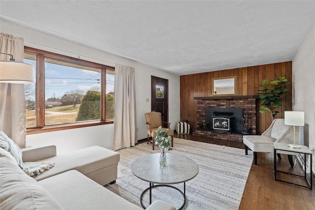 living area with light wood-style flooring, a wood stove, and wood walls