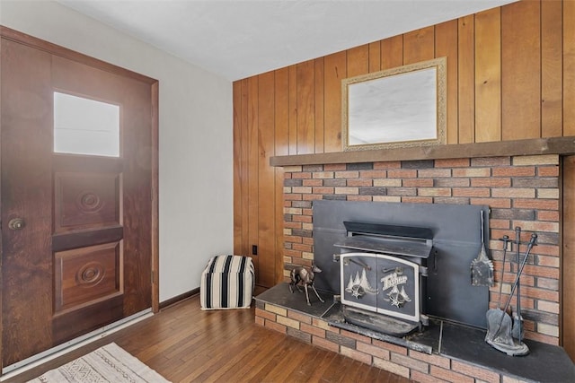 details featuring a wood stove, baseboards, and wood finished floors