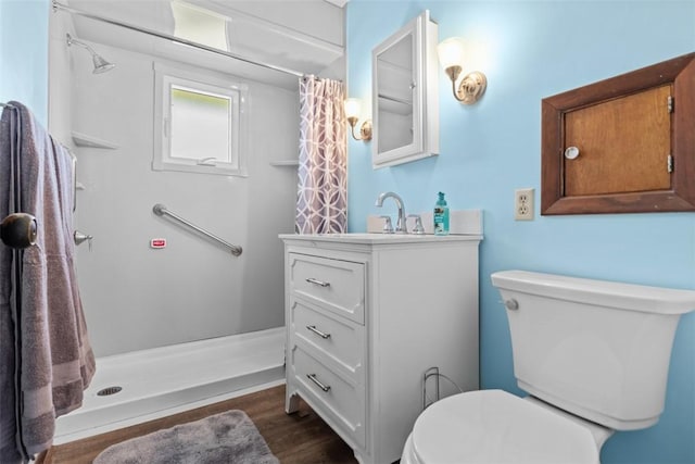 bathroom featuring a shower with curtain, wood finished floors, toilet, and vanity