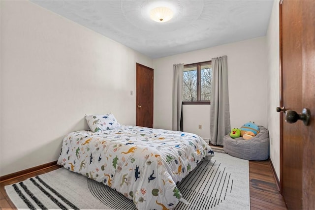 bedroom with baseboards and wood finished floors