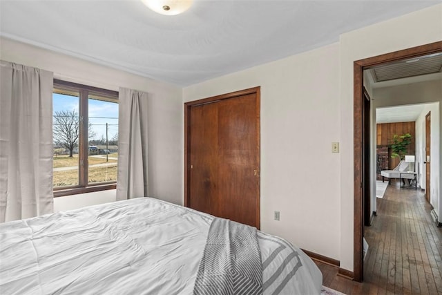 bedroom featuring hardwood / wood-style flooring, baseboards, and a closet