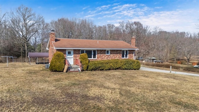 view of front of house featuring a front yard, brick siding, and a chimney