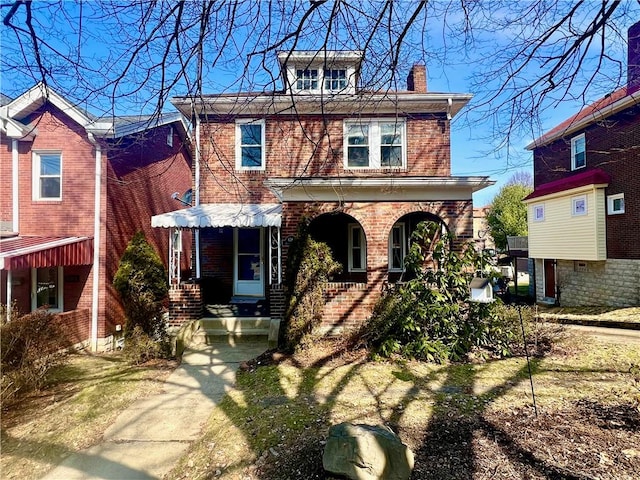 american foursquare style home with brick siding and a chimney