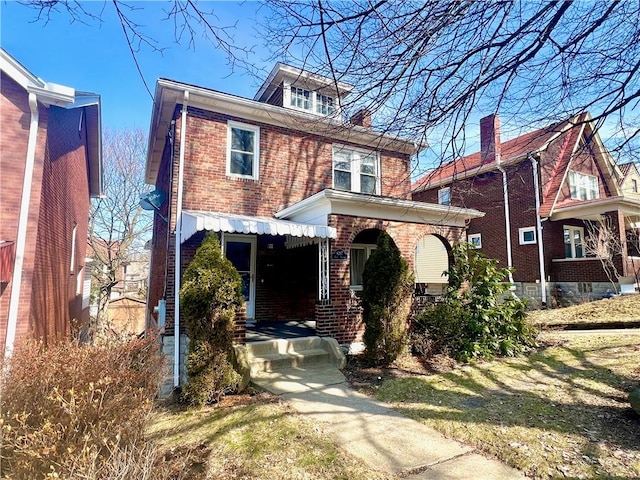 american foursquare style home featuring brick siding