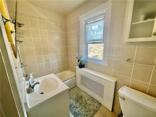 bathroom with toilet, vanity, bathtub / shower combination, tile patterned floors, and tile walls