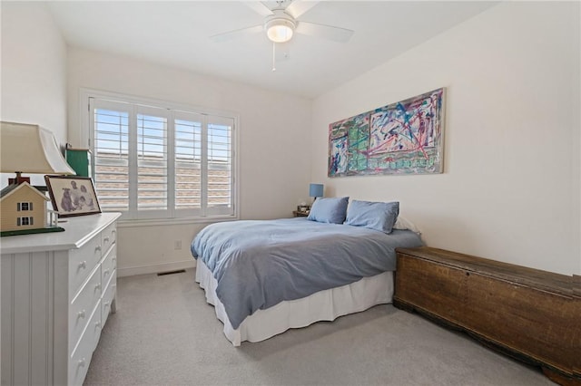 bedroom with a ceiling fan, light colored carpet, visible vents, and baseboards