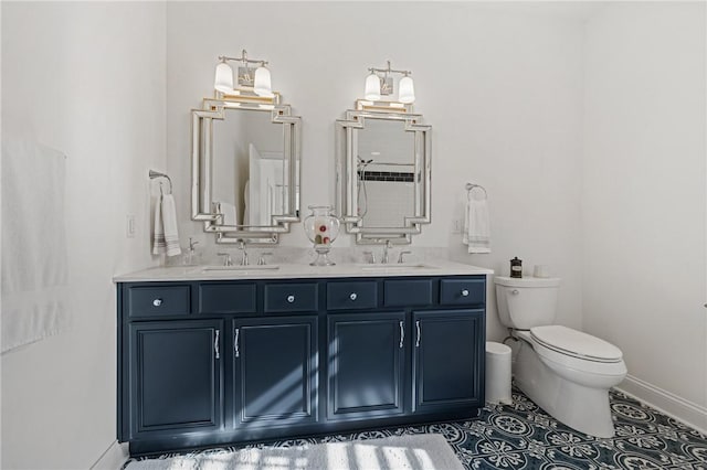 bathroom with a sink, baseboards, toilet, and double vanity