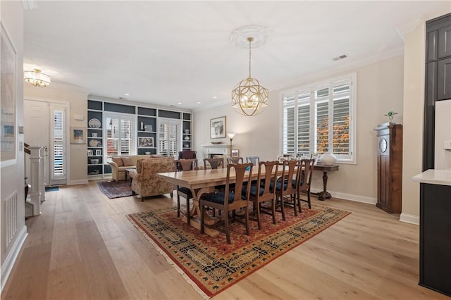 dining area featuring visible vents, a notable chandelier, ornamental molding, plenty of natural light, and light wood-style floors