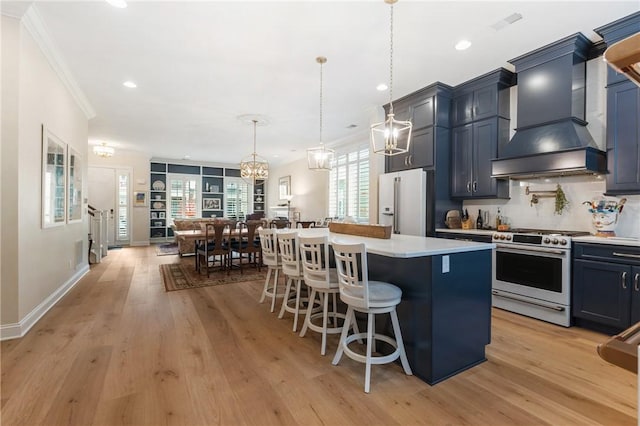 kitchen with a breakfast bar, light countertops, stainless steel stove, white fridge with ice dispenser, and custom exhaust hood