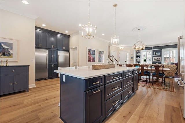 kitchen featuring light wood-type flooring, built in refrigerator, an inviting chandelier, and ornamental molding