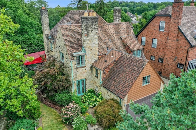 exterior space featuring a high end roof, stone siding, and a chimney