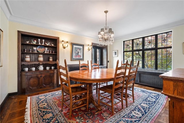 dining room with baseboards, an inviting chandelier, wood finished floors, and crown molding