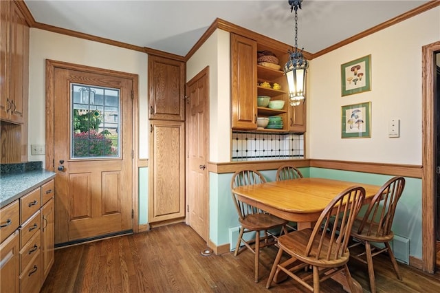 dining room with dark wood-type flooring and crown molding