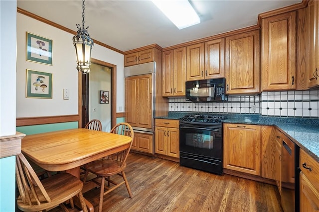 kitchen with brown cabinets, dark countertops, black appliances, and crown molding