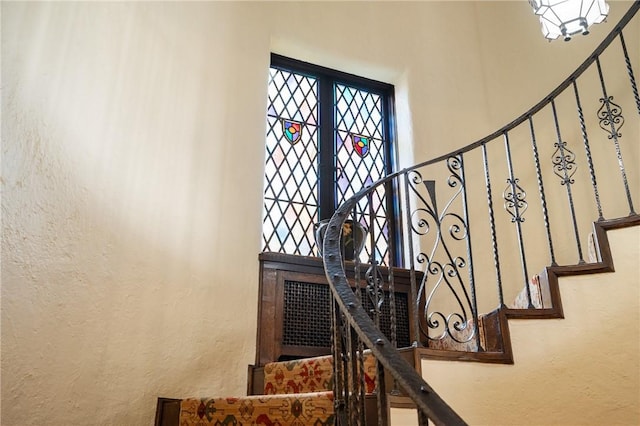 stairs featuring a wealth of natural light and a textured wall