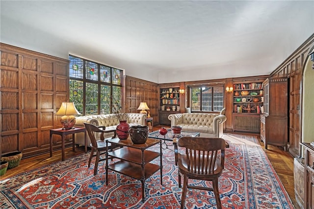 living area featuring built in features and wooden walls