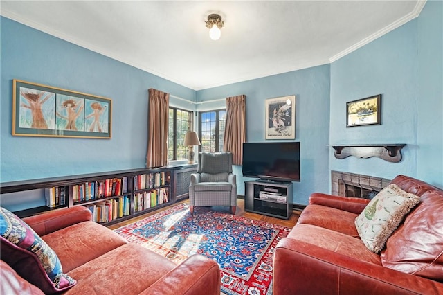 living room featuring ornamental molding, a fireplace, and wood finished floors