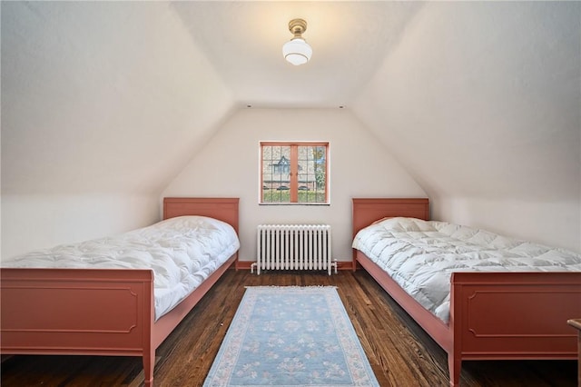 bedroom with radiator, lofted ceiling, and wood finished floors