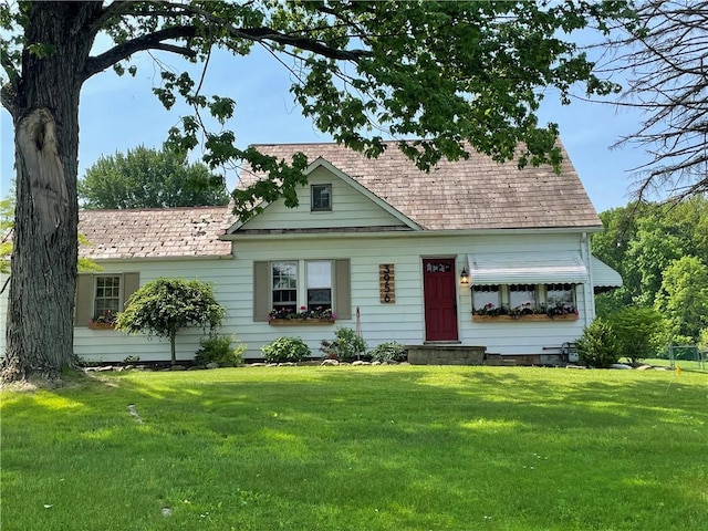 cape cod home featuring a front yard