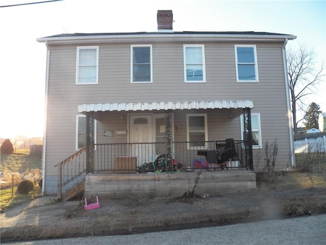 view of front of property with a porch and a chimney