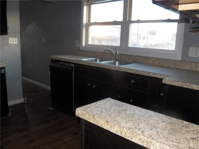 kitchen with dark wood-style flooring, a healthy amount of sunlight, dishwasher, and a sink