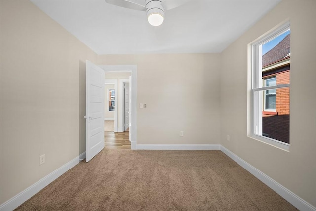 spare room featuring a ceiling fan, carpet, and baseboards