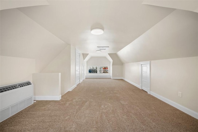 additional living space featuring carpet flooring, radiator, baseboards, and vaulted ceiling