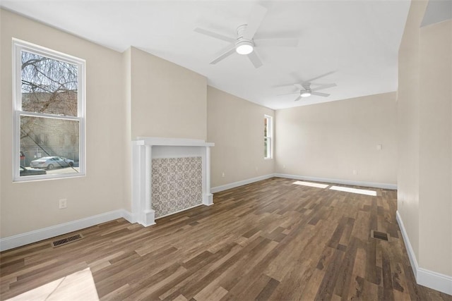 unfurnished living room featuring visible vents, a tile fireplace, baseboards, and wood finished floors