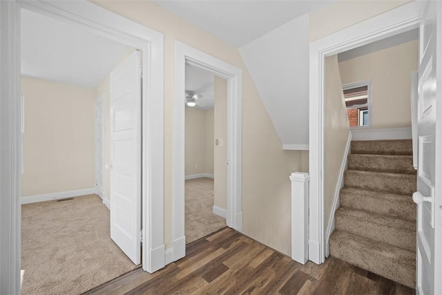 stairway featuring visible vents, baseboards, and wood finished floors