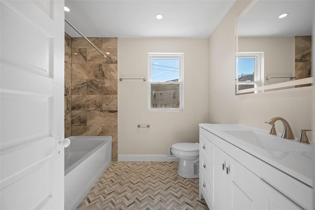 bathroom with a wealth of natural light, baseboards, toilet, and vanity