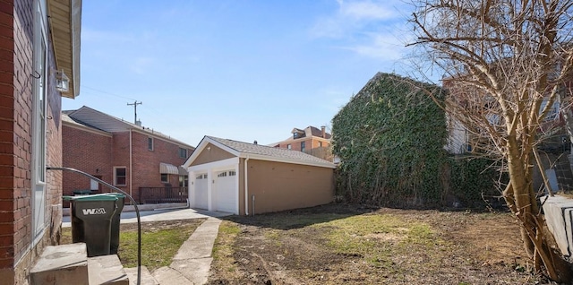 exterior space featuring a garage, an outdoor structure, and fence