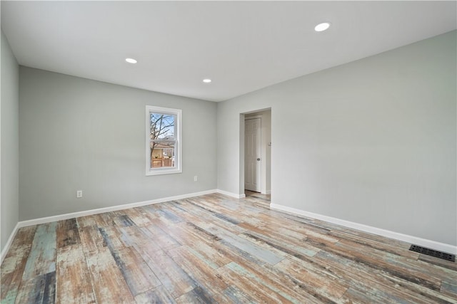 unfurnished room with recessed lighting, visible vents, baseboards, and wood finished floors