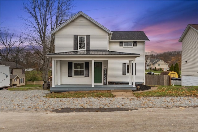 view of front of house with covered porch and fence