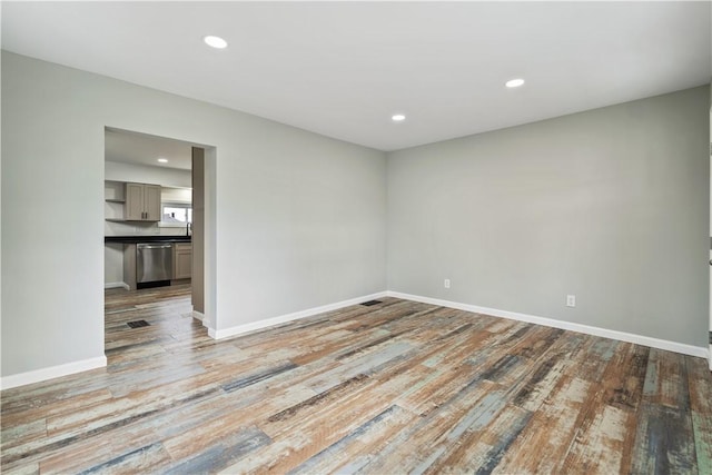 empty room with recessed lighting, light wood-style flooring, and baseboards