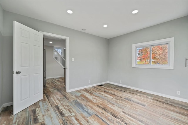 unfurnished room with visible vents, recessed lighting, baseboards, and wood finished floors