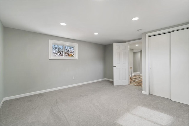 unfurnished bedroom featuring recessed lighting, a closet, carpet floors, and baseboards