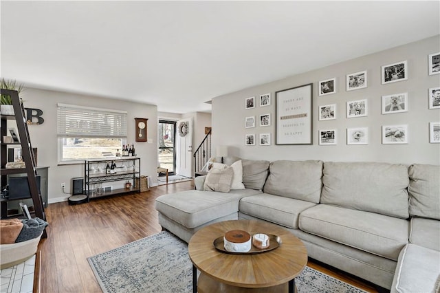 living area featuring stairs, baseboards, and wood finished floors