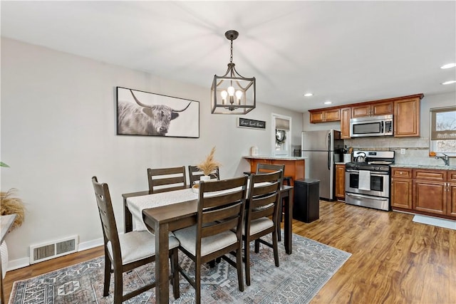 dining space featuring light wood-type flooring, visible vents, baseboards, and recessed lighting