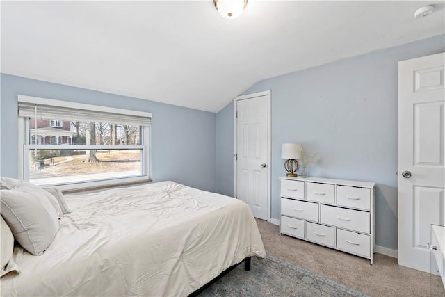 bedroom featuring lofted ceiling, light colored carpet, and baseboards