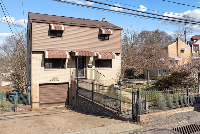 view of front of house with a fenced front yard, driveway, an attached garage, and a gate