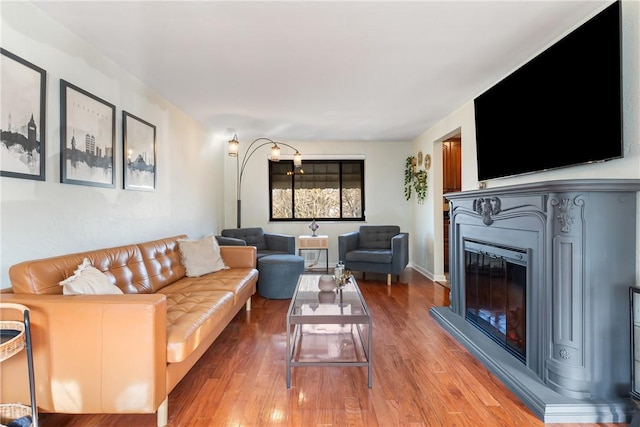 living area featuring light wood finished floors and a glass covered fireplace