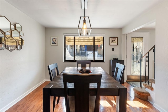 dining room featuring stairway, baseboards, and wood finished floors