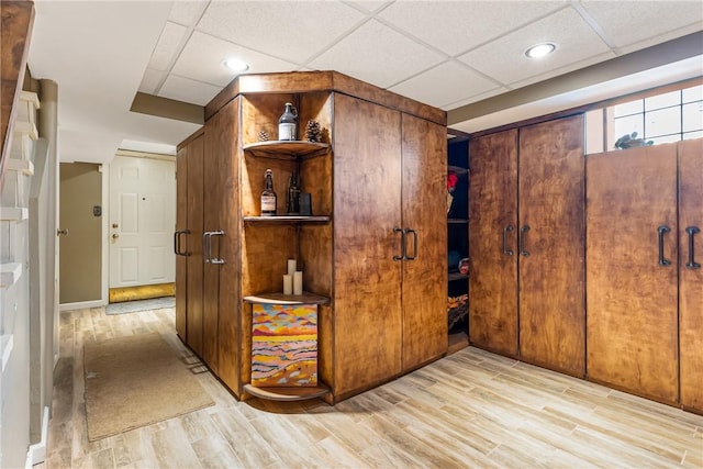 bar with a paneled ceiling and wood finished floors